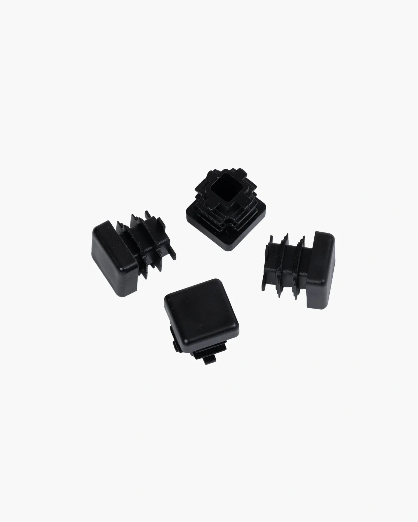 Set of four stylish black plastic feet for furniture protection and floor safety.
